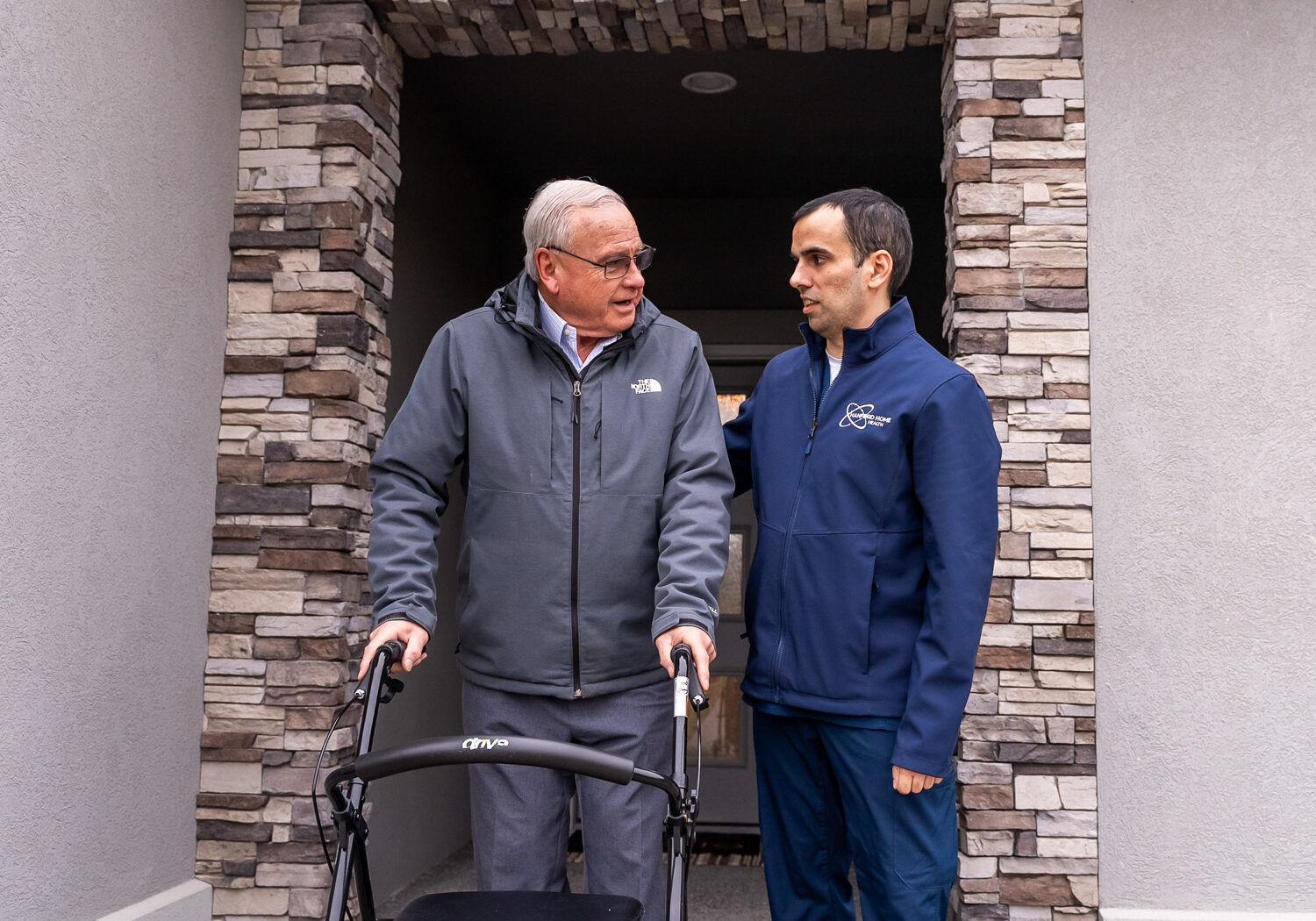 nurse and patient with walker standing outside home